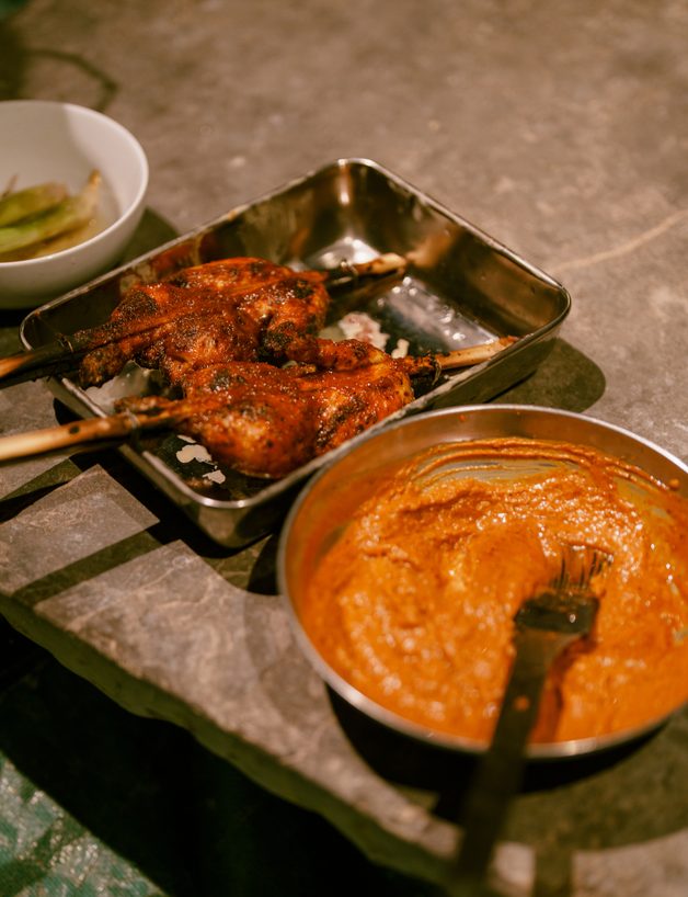 Grilled skewers served with a bowl of peanut sauce